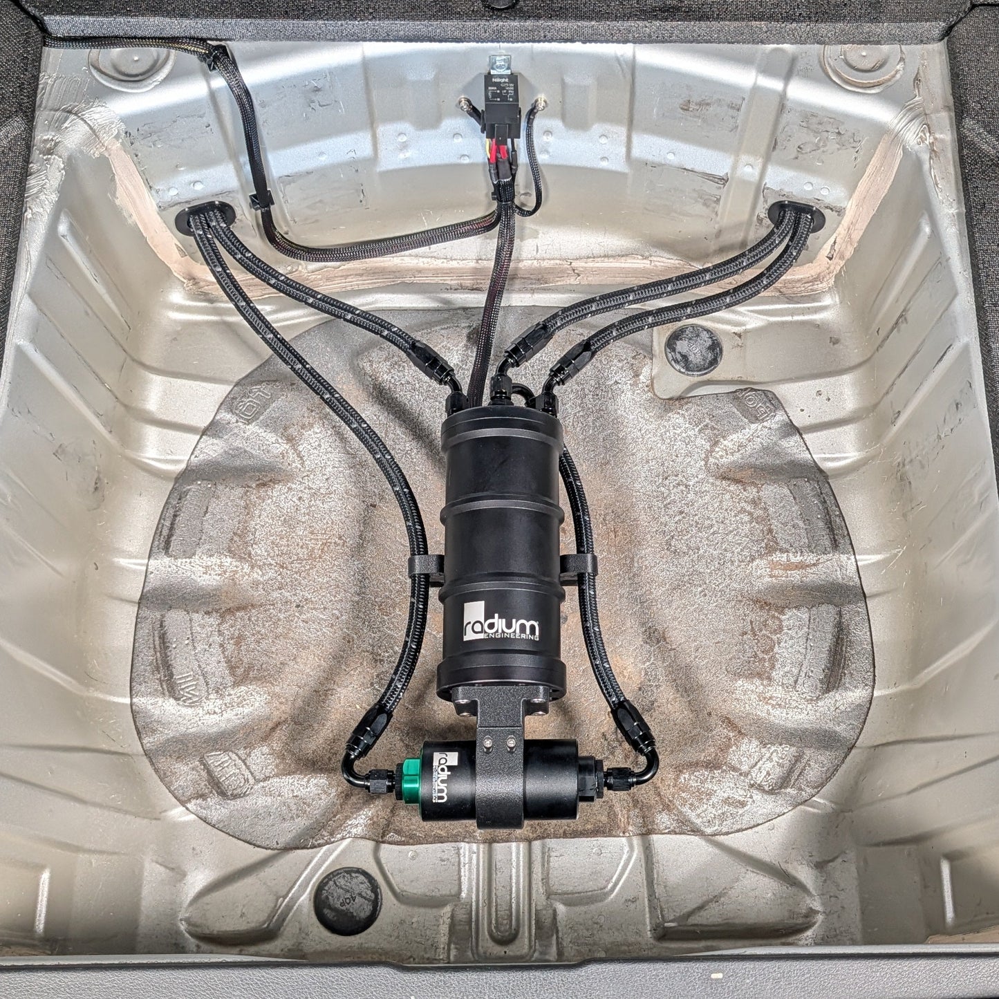 Radium Surge Tank and Fuel Filter Mounted in the Spare Tire Well of a Subaru