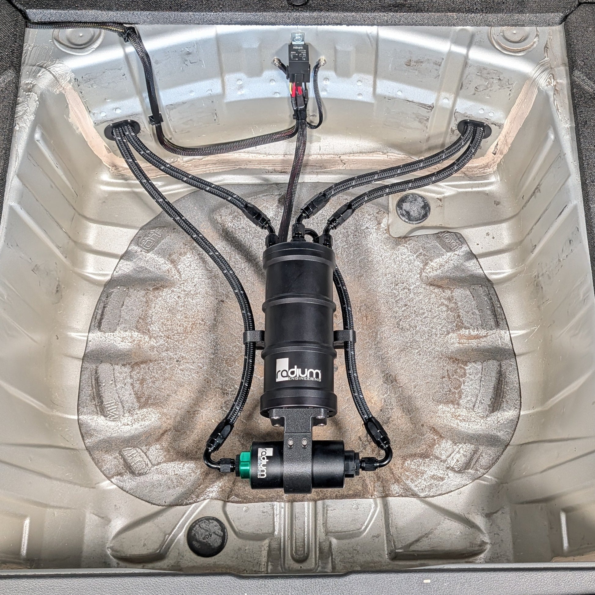 Radium Surge Tank and Fuel Filter Mounted in the Spare Tire Well of a Subaru